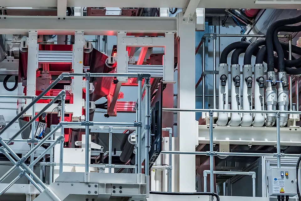 The production plant: walkways, ducts and rollers under red light
