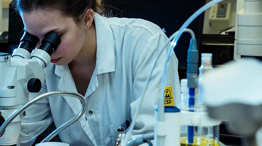 A technician at the microscope in the on-site laboratory