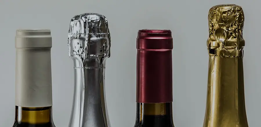 Four wine and sparkling wine bottles with aluminium capsules